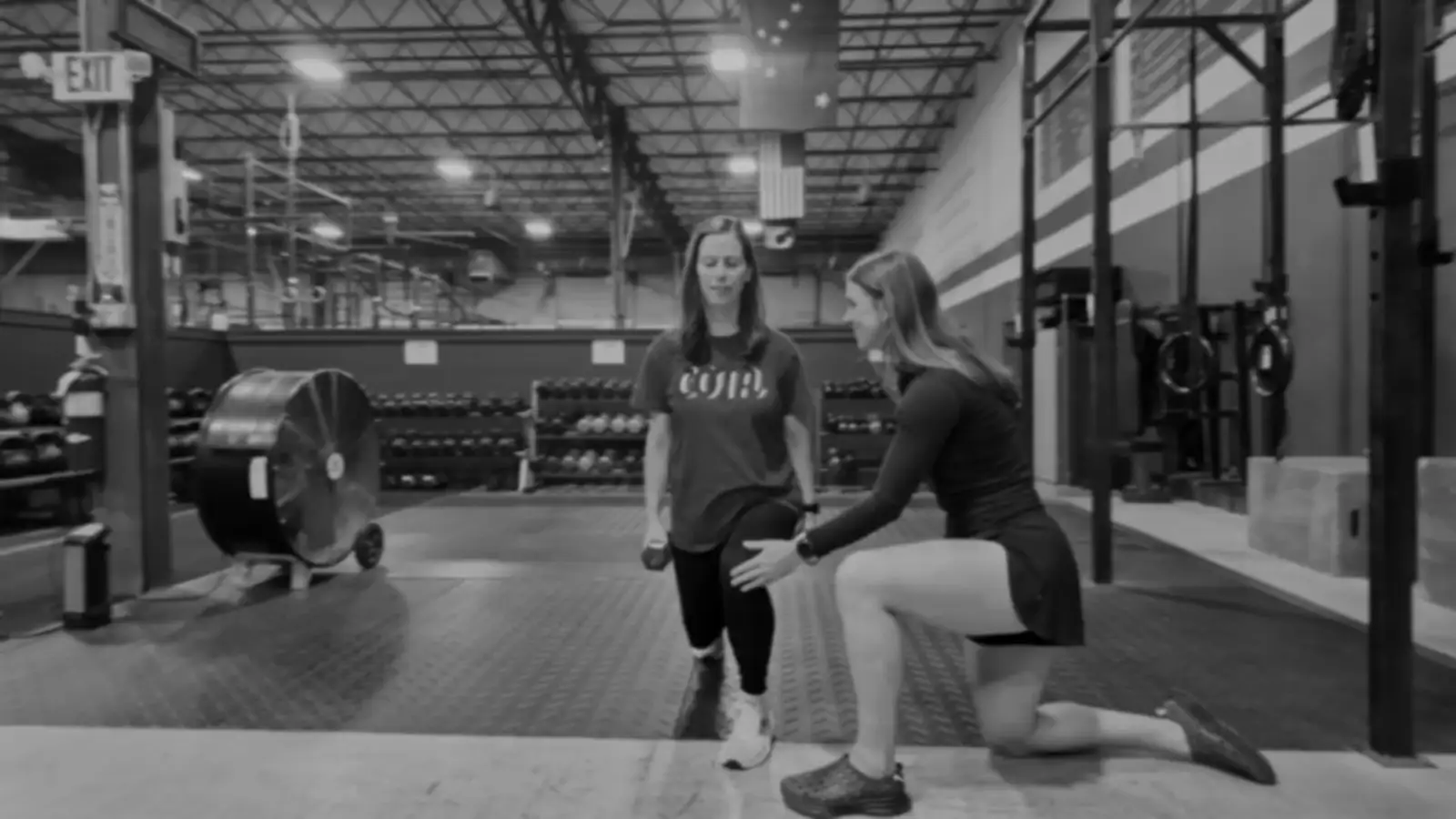 Kiley Robb, PT, DPT, coaches an athlete through a lunge in the gym