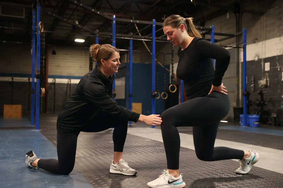 Dr. Kiley coaches an athlete through a lunge in the gym